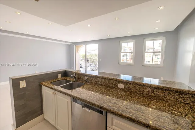 a kitchen with granite countertop sink stove and window