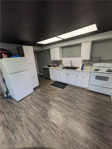 a kitchen with a stove wooden floor and cabinets