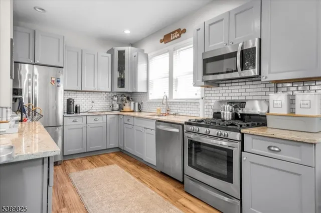 a kitchen with stainless steel appliances granite countertop a stove sink and cabinets