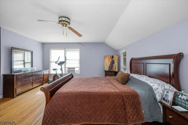 a bedroom with a large bed and wooden floor
