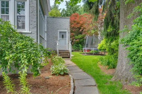 a view of a house with a yard and potted plants