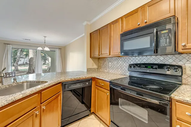 a view of a kitchen with granite countertop sink and cabinets