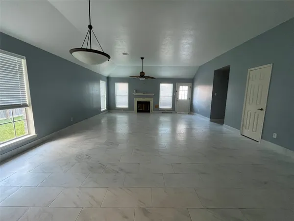 a view of a livingroom with a fireplace window and wooden floor