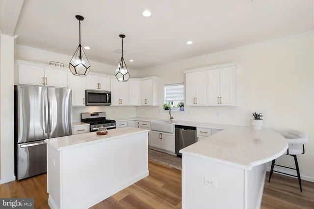 a kitchen that has a kitchen island wooden cabinets and stainless steel appliances