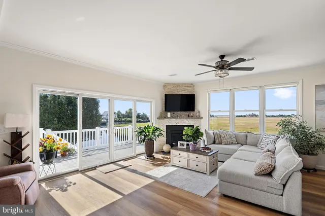 a living room with furniture a floor to ceiling window and a flat screen tv