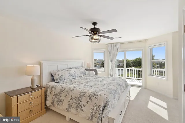 a bedroom with a large bed and a chandelier fan