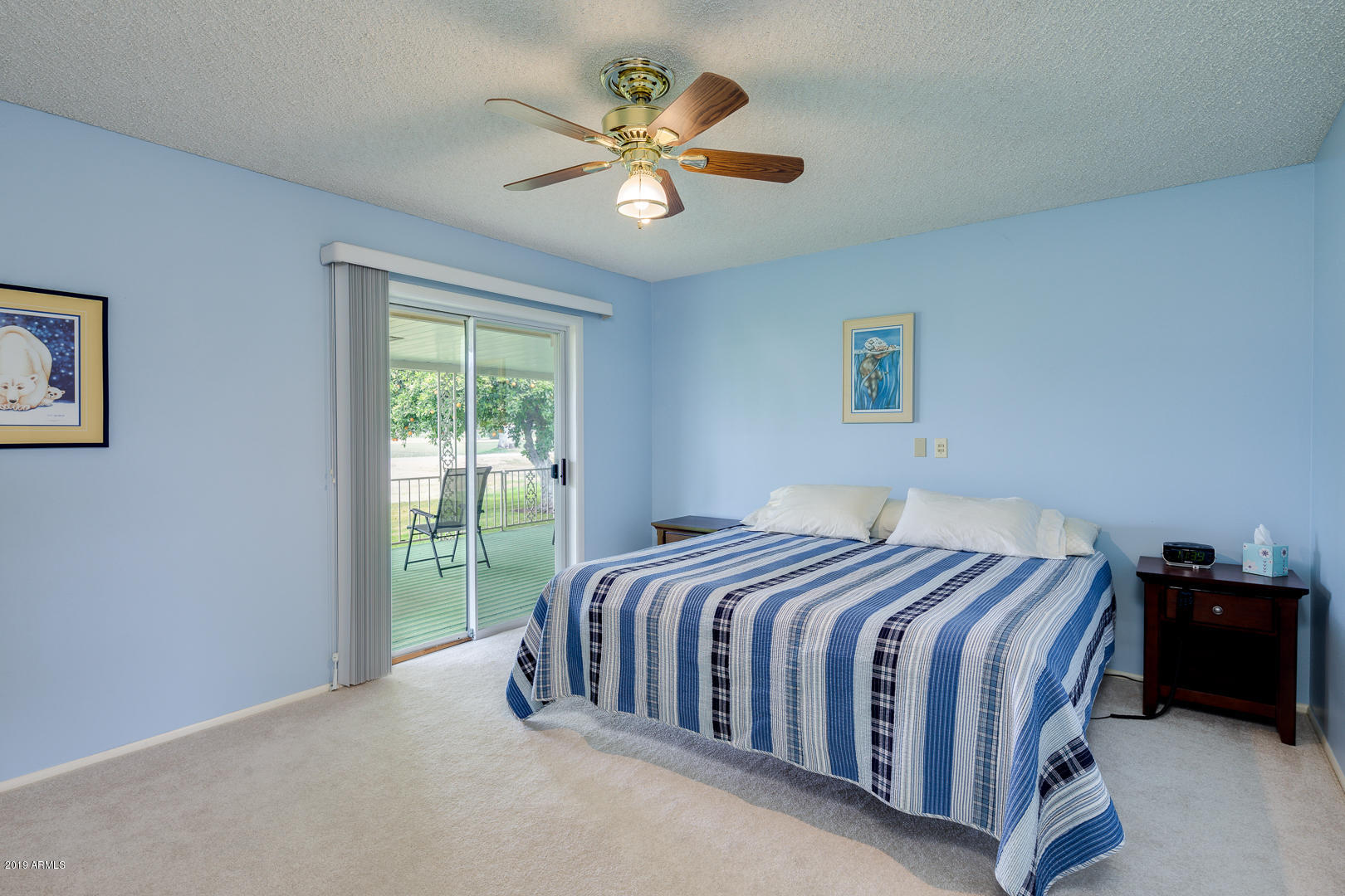 10030 West Mountain View Road Sun City, AZ 85351 - Photo 11 of 16 a bedroom with a bed and a ceiling fan