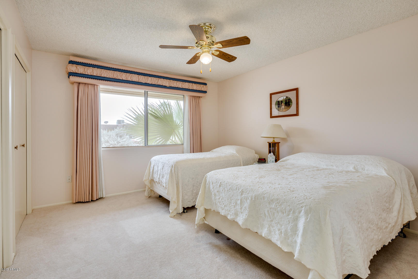 10030 West Mountain View Road Sun City, AZ 85351 - Photo 13 of 16 a bedroom with two beds and a large window