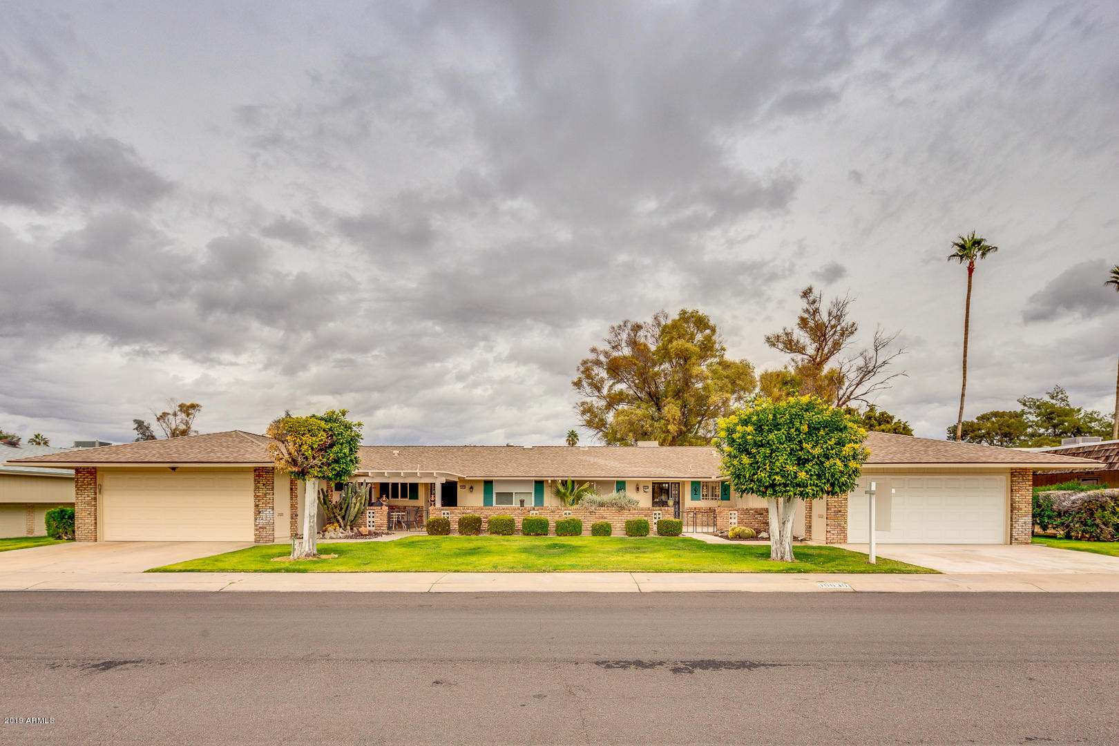 10030 West Mountain View Road Sun City, AZ 85351 - Photo 2 of 16 a front view of a house with a yard and trees