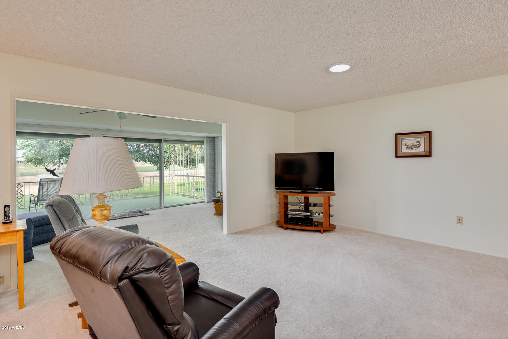 10030 West Mountain View Road Sun City, AZ 85351 - Photo 7 of 16 a living room with furniture and a flat screen tv