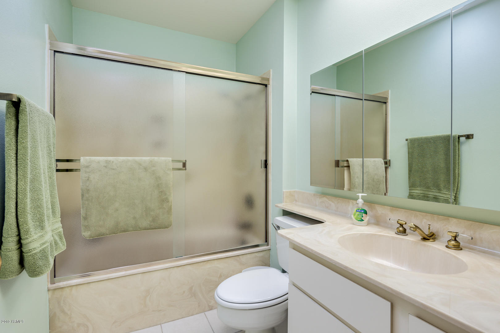 10030 West Mountain View Road Sun City, AZ 85351 - Photo 10 of 16 a bathroom with a sink a mirror toilet and shower
