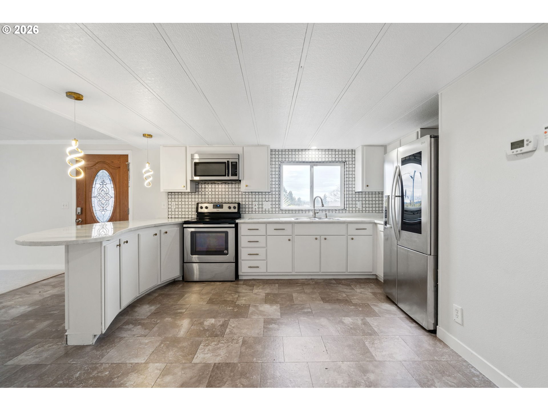 8525 Southeast Orchard Lane, Unit 91 Happy Valley, OR 97086 - Photo 12 of 35 a kitchen with granite countertop a refrigerator and cabinets