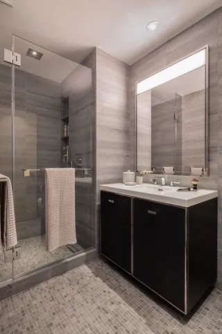 a bathroom with a double sink shower and a mirror