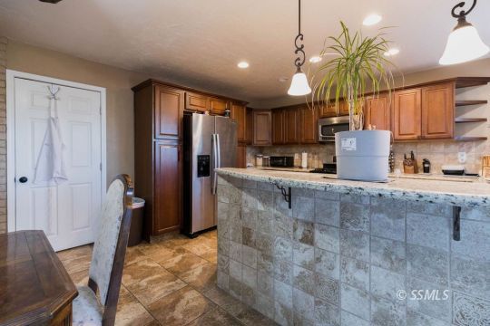925 West St George Avenue Ridgecrest, CA 93555 - Photo 12 of 24 a kitchen with stainless steel appliances granite countertop a refrigerator a stove and a sink