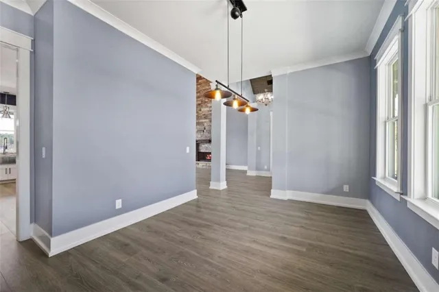 a view of an empty room with window and wooden floor