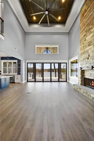 a view of an empty room with glass door and wooden floor