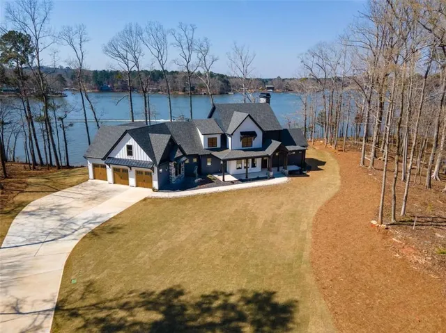 an aerial view of a house with outdoor space and lake view