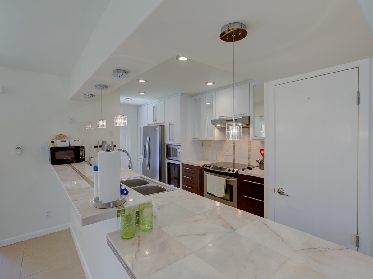 710 Castle Ridge Road, Unit B Austin, TX 78746 - Photo 6 of 27 A well-appointed kitchen showcasing elegant marble countertops and contemporary pendant lighting.