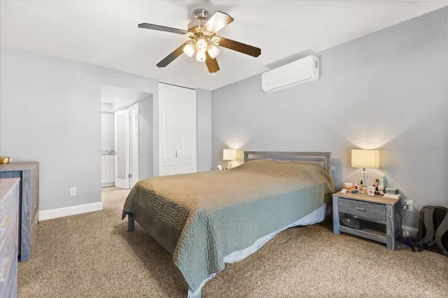 a spacious bedroom with a bed and a ceiling fan