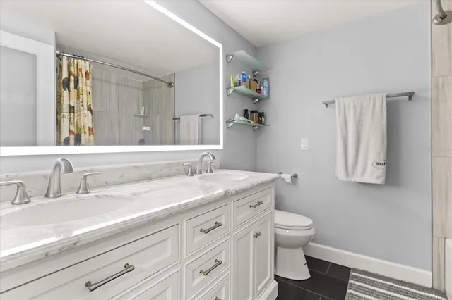 a bathroom with a granite countertop toilet sink and mirror