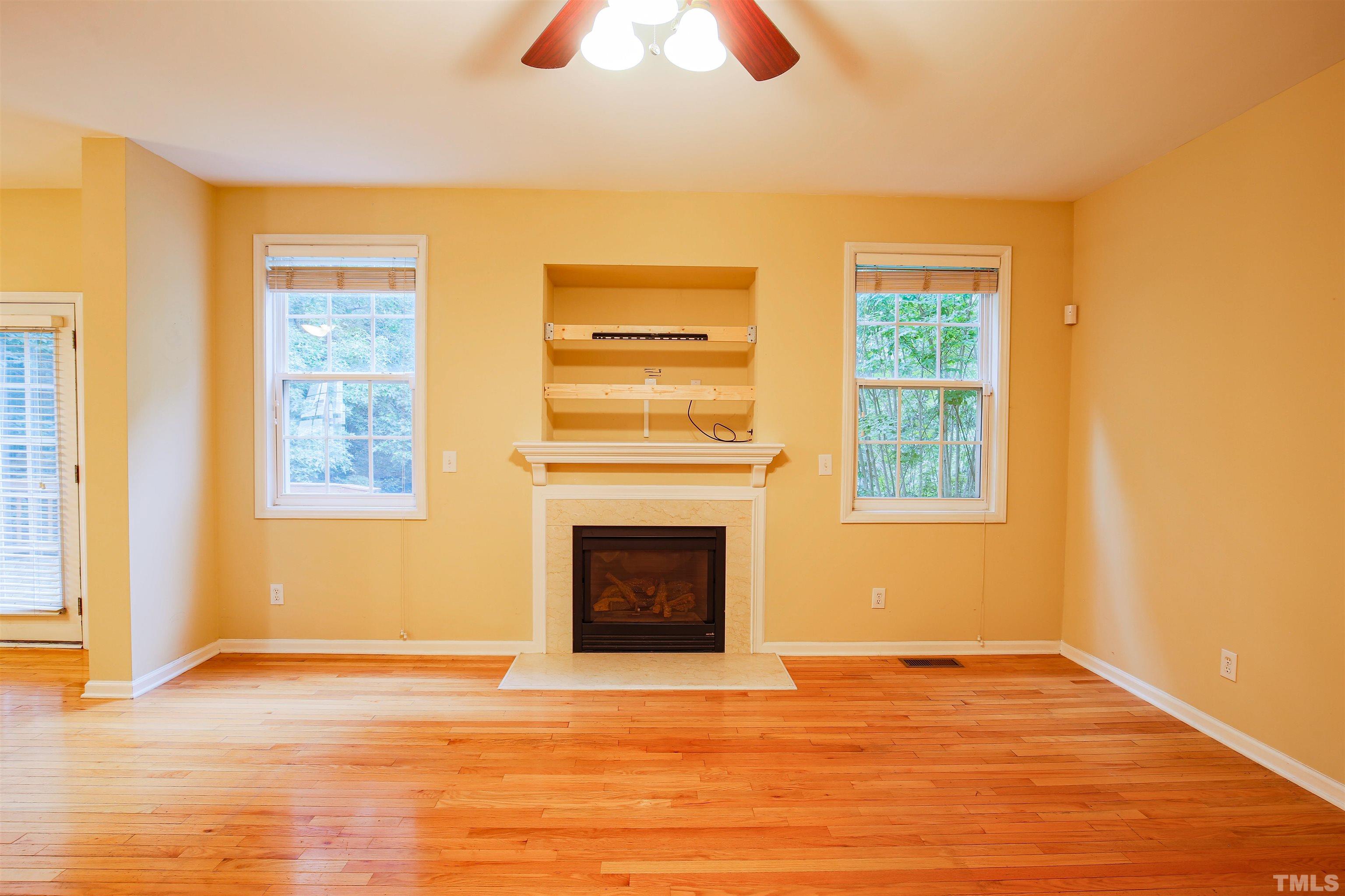 2208 Spruce Shadows Lane Raleigh, NC 27614 - Photo 13 of 26 a view of an empty room with wooden floor and a window
