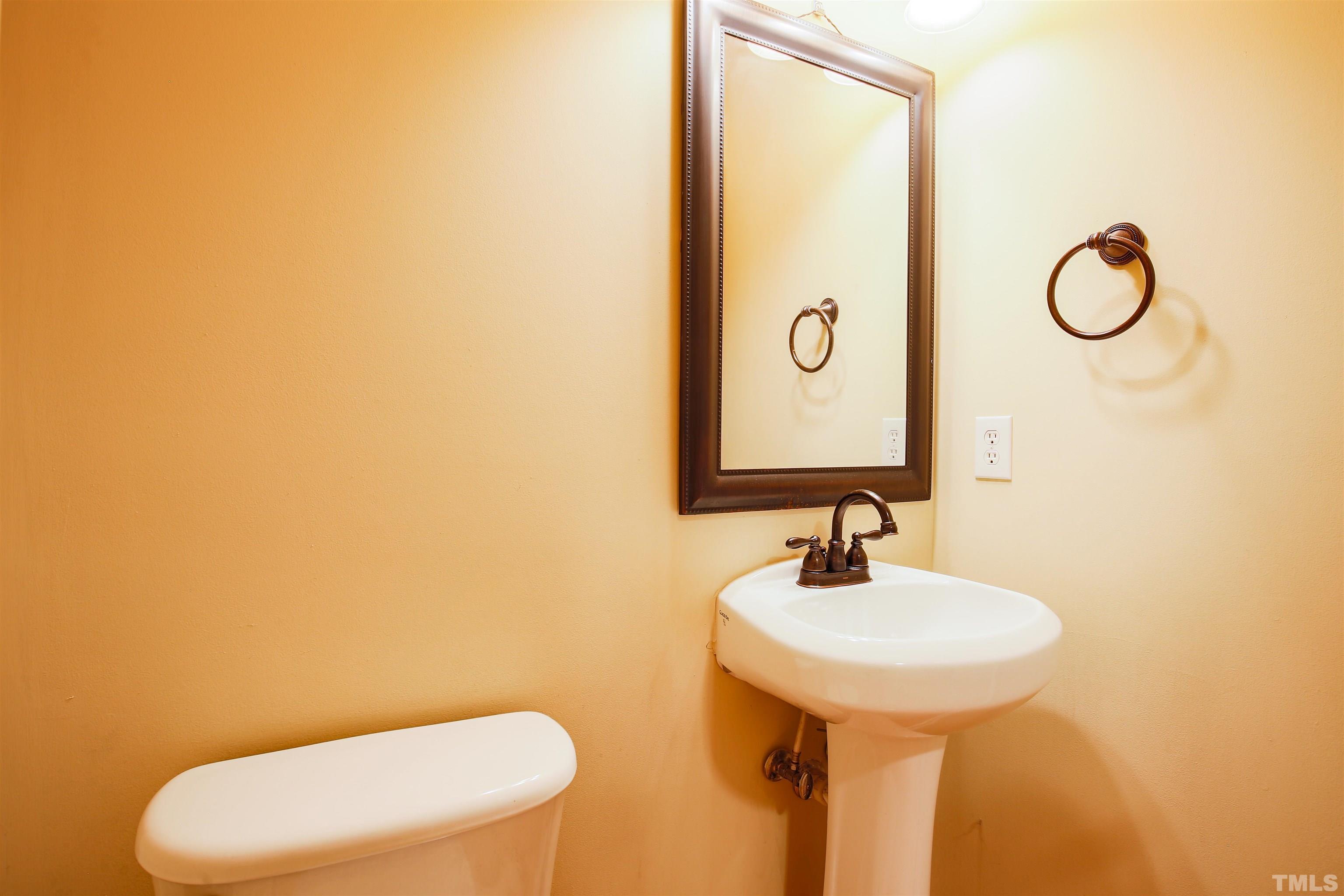 2208 Spruce Shadows Lane Raleigh, NC 27614 - Photo 14 of 26 a bathroom with a toilet sink and mirror