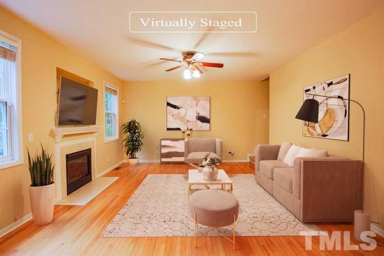 2208 Spruce Shadows Lane Raleigh, NC 27614 - Photo 2 of 26 a living room with furniture a flat screen tv and a fireplace