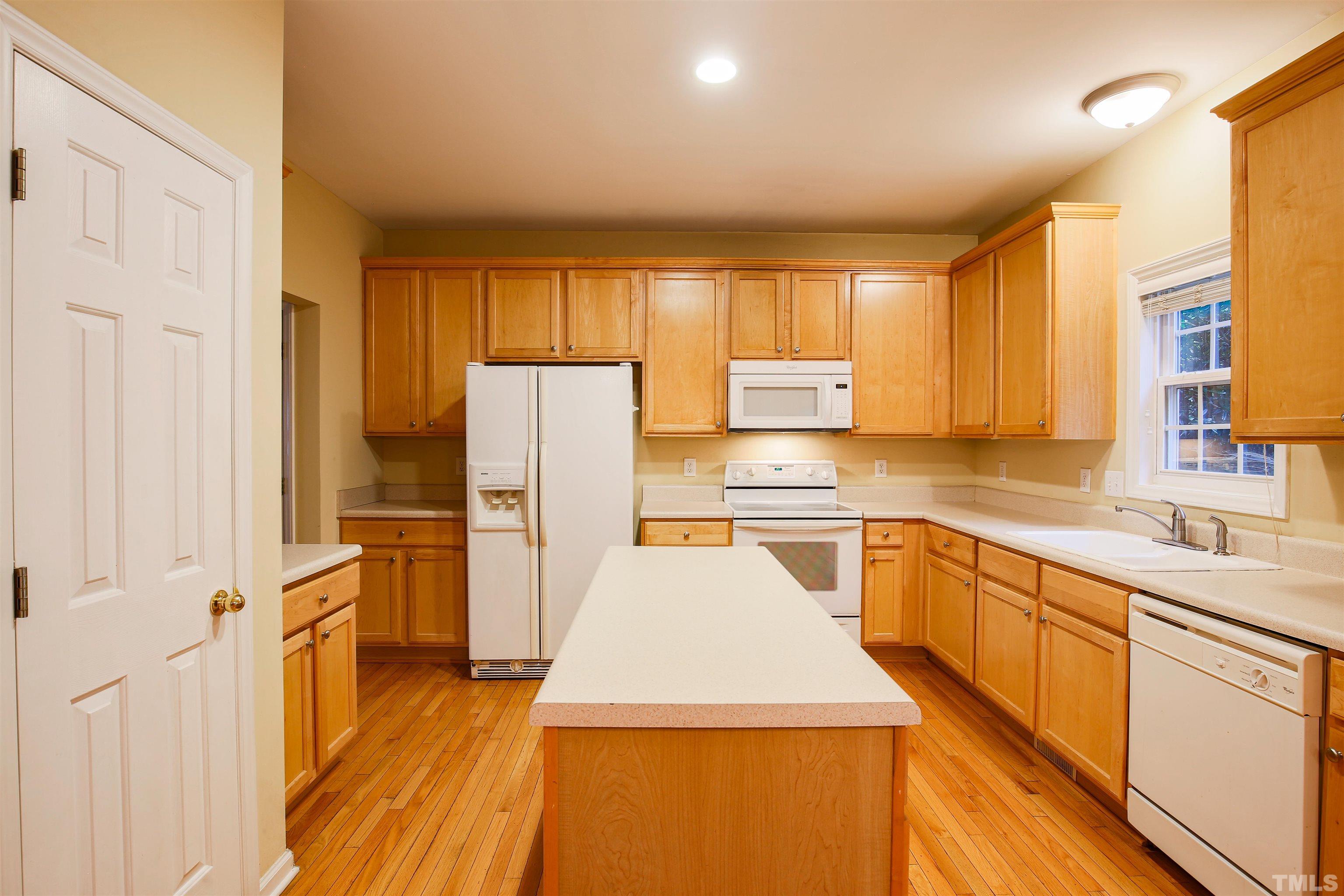 2208 Spruce Shadows Lane Raleigh, NC 27614 - Photo 4 of 26 a kitchen with cabinets and wooden floor