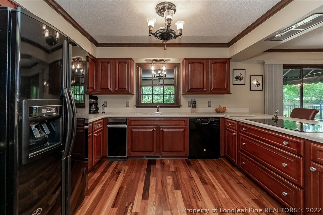 503 Queensferry Road Cary, NC 27511 - Photo 30 of 49 a kitchen with stainless steel appliances granite countertop a refrigerator a sink dishwasher a stove and white countertops with wooden floor