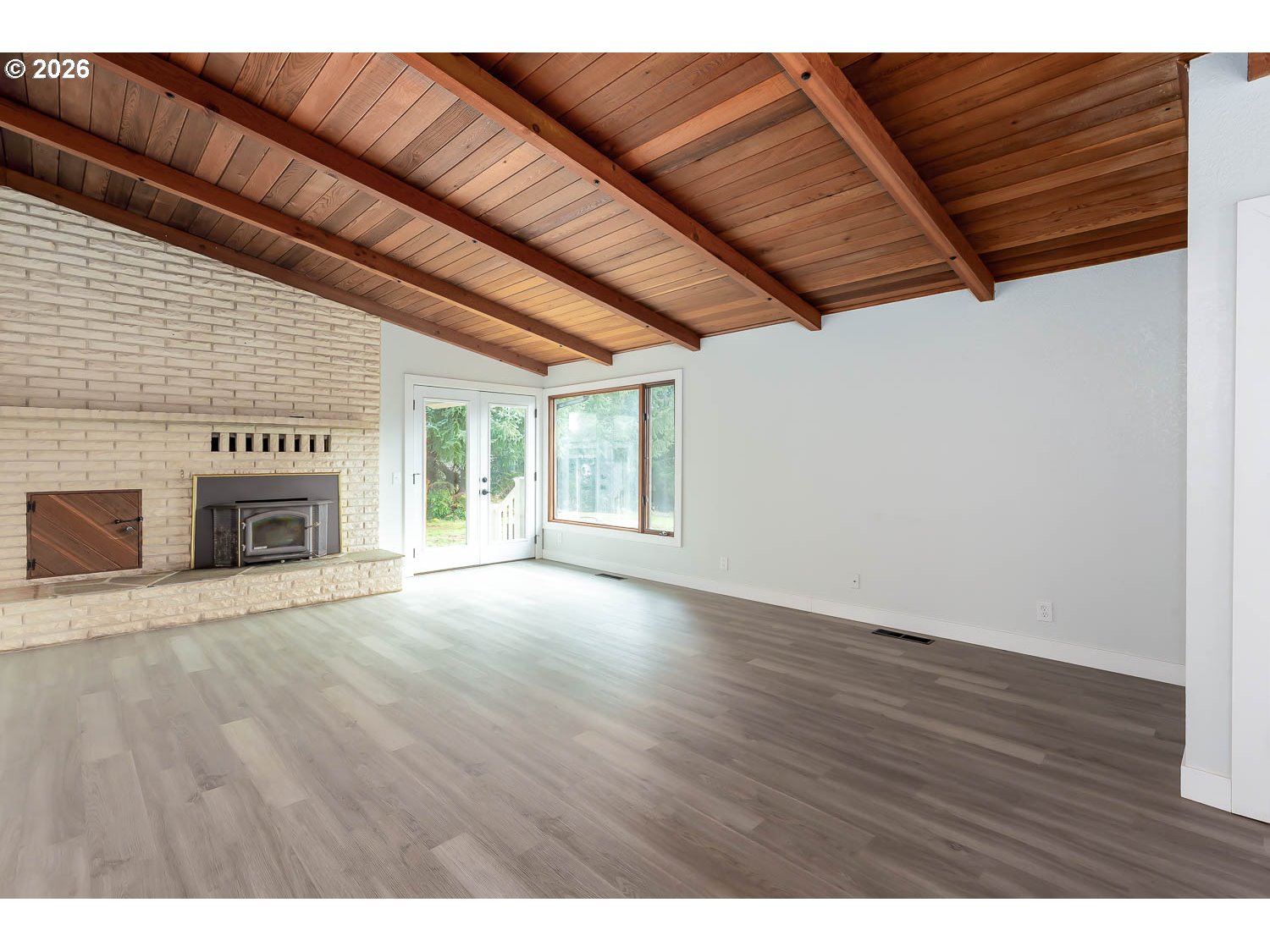 48187 McFarland Road Oakridge, OR 97463 - Photo 16 of 41 a view of an empty room with wooden floor and a fireplace