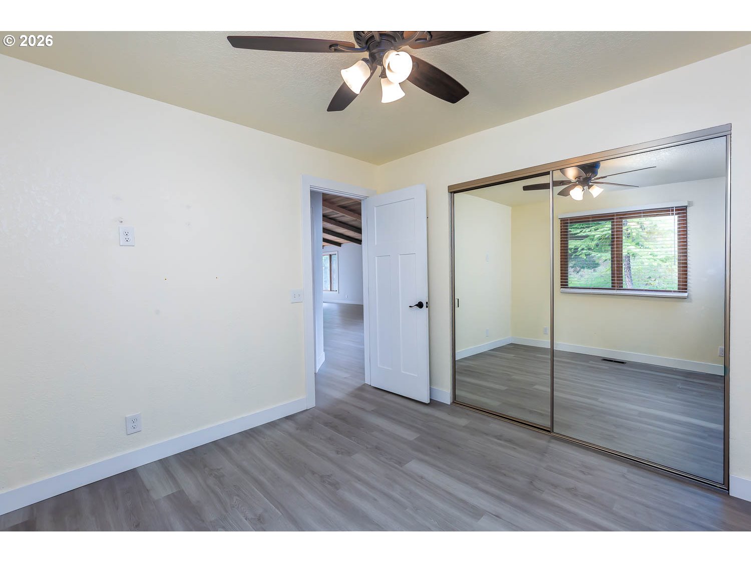 48187 McFarland Road Oakridge, OR 97463 - Photo 28 of 41 an empty room with wooden floor chandelier fan and windows