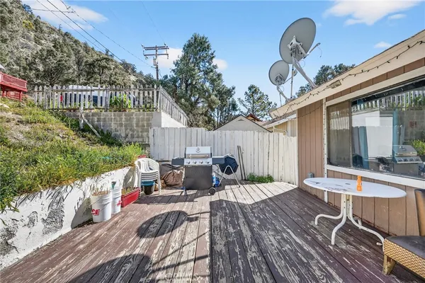 a view of a house with wooden deck and furniture