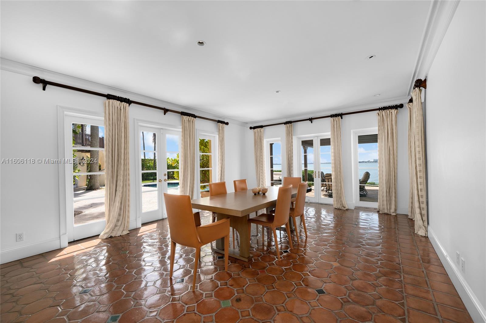 4810 North Bay Road Miami Beach, FL 33140 - Photo 26 of 61 a view of a dining room with furniture and floor to ceiling windows