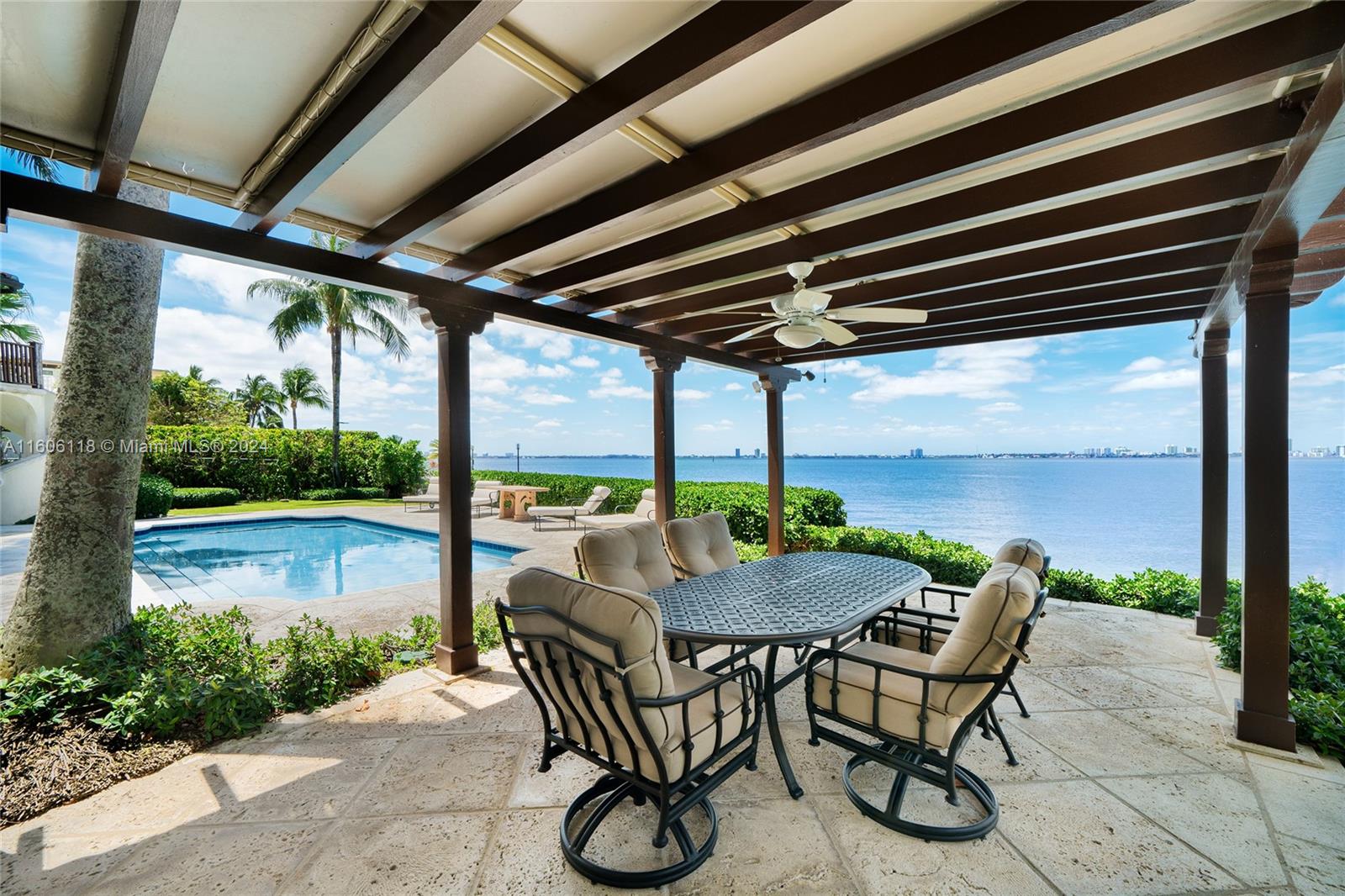 4810 North Bay Road Miami Beach, FL 33140 - Photo 28 of 61 a view of patio with table and chairs and floor to ceiling window with wooden floor