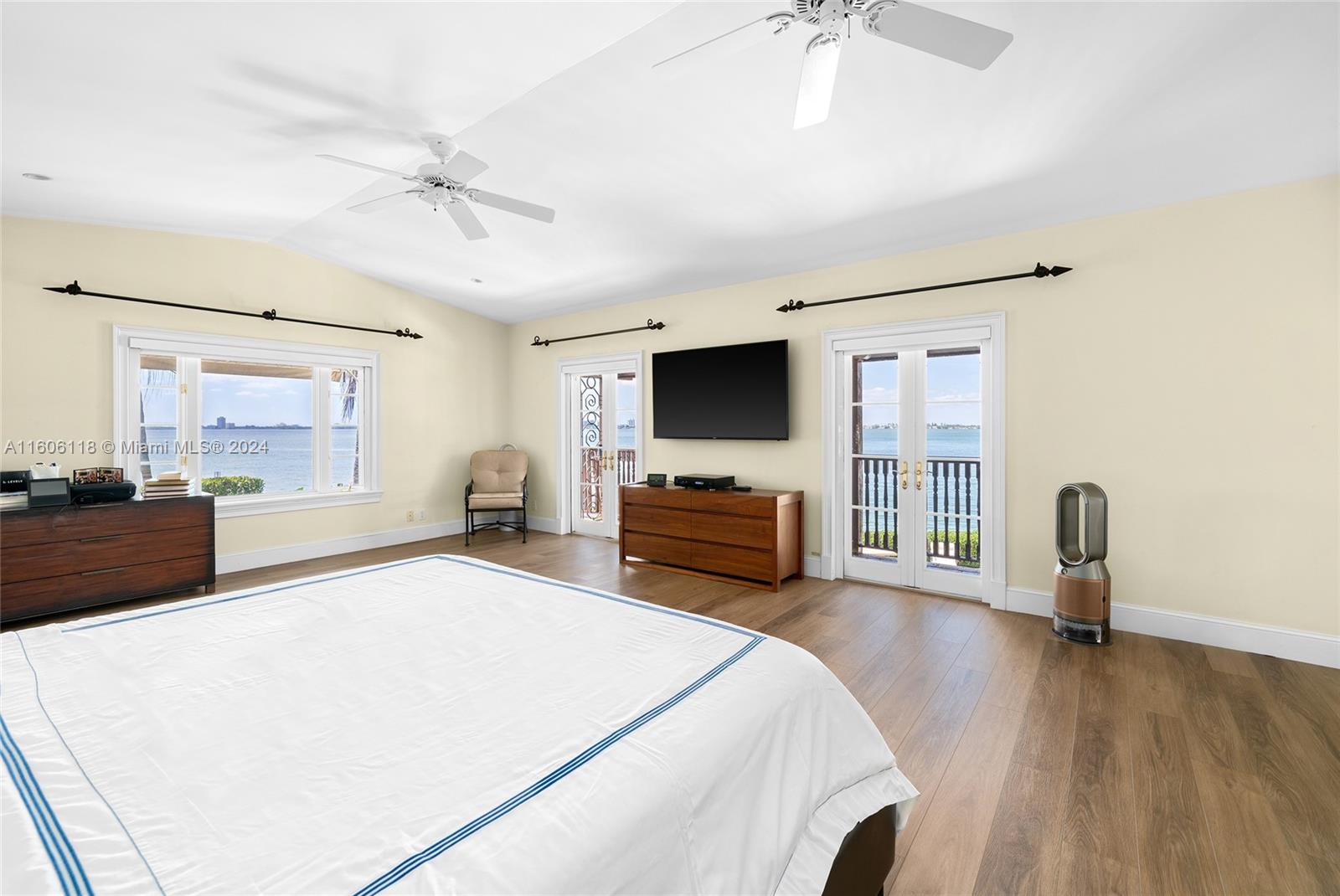 4810 North Bay Road Miami Beach, FL 33140 - Photo 40 of 61 a spacious bedroom with a bed and a flat tv screen on dresser