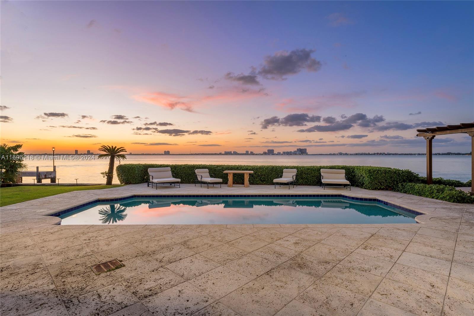 4810 North Bay Road Miami Beach, FL 33140 - Photo 6 of 61 a view of a swimming pool with a table and chairs