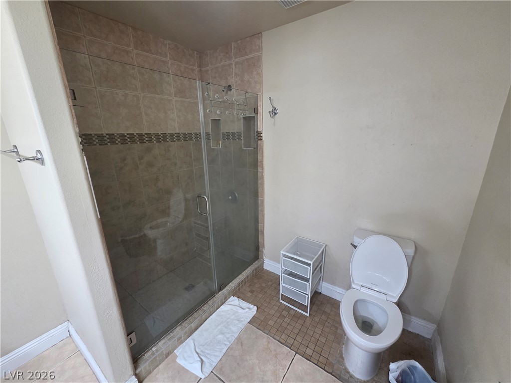 3381 Westwind Road Las Vegas, NV 89146 - Photo 46 of 52 A well-appointed bathroom features a glass-enclosed shower and practical tile flooring.