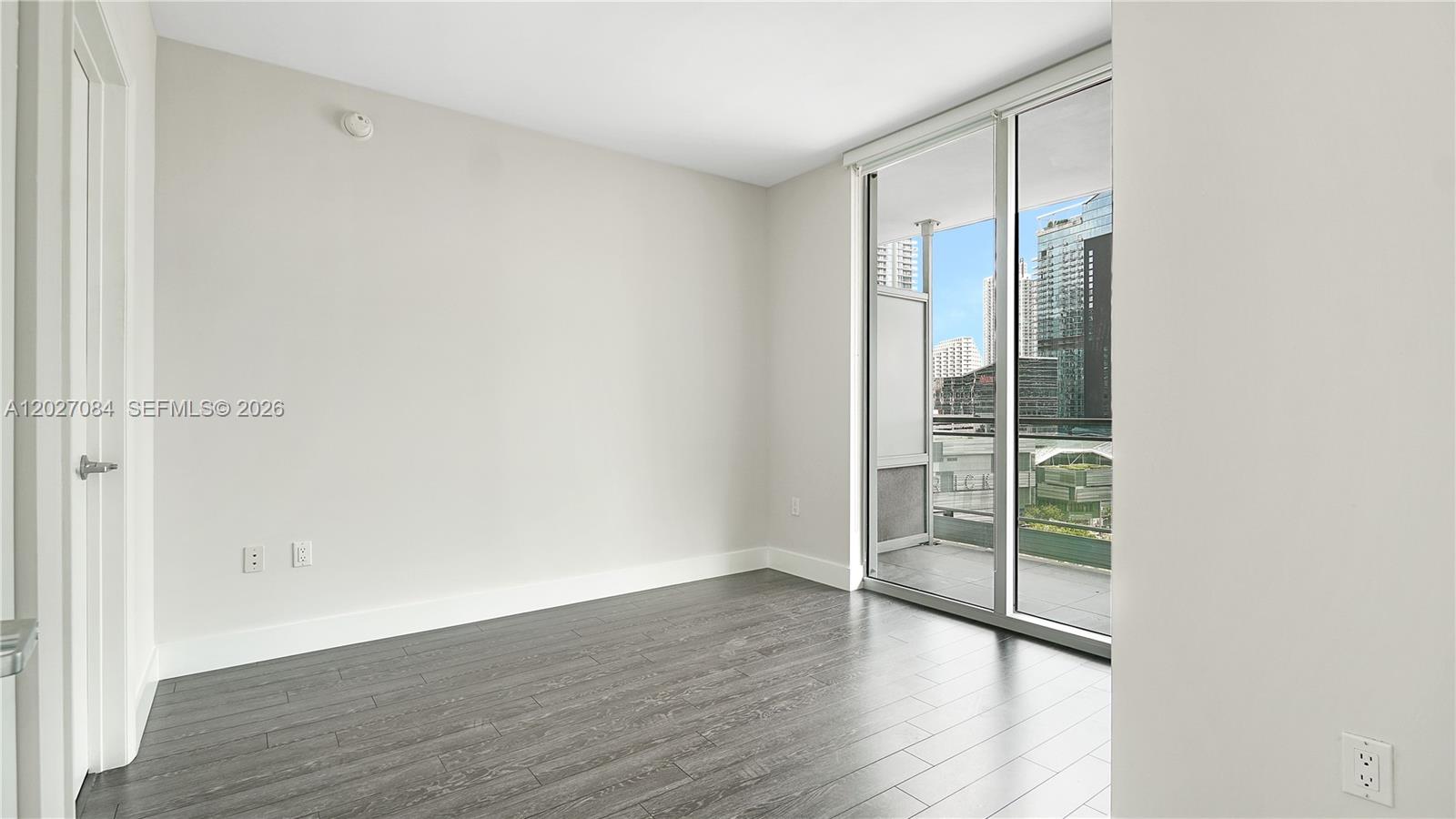 92 Southwest 3rd Street, Unit 1803 Miami, FL 33130 - Photo 11 of 29 an empty room with wooden floor and windows