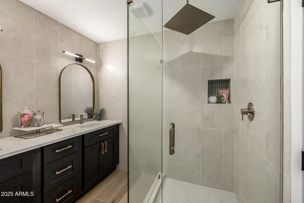a bathroom with a double vanity sink mirror and shower