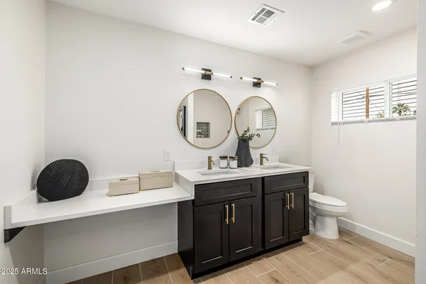 a bathroom with a toilet a sink and a mirror