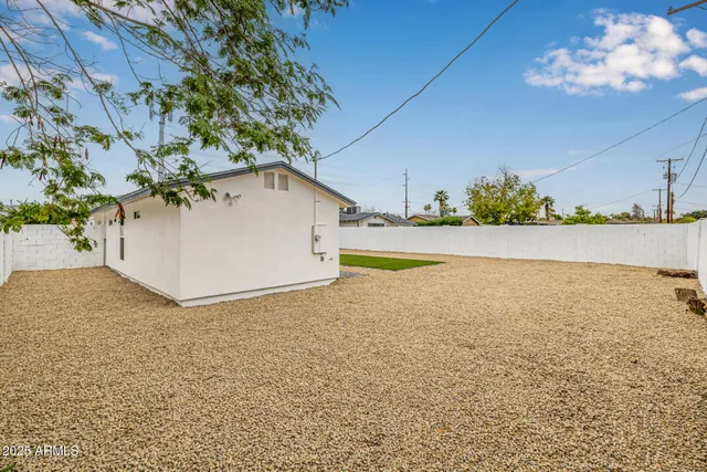 a white house with a white bed and a yard