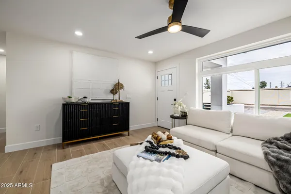 a living room with furniture and a ceiling fan