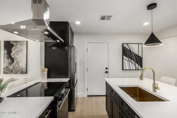 a kitchen with stainless steel appliances kitchen island a refrigerator and a sink