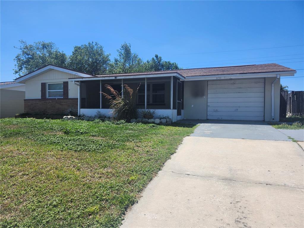 a front view of house with yard and trees in the background