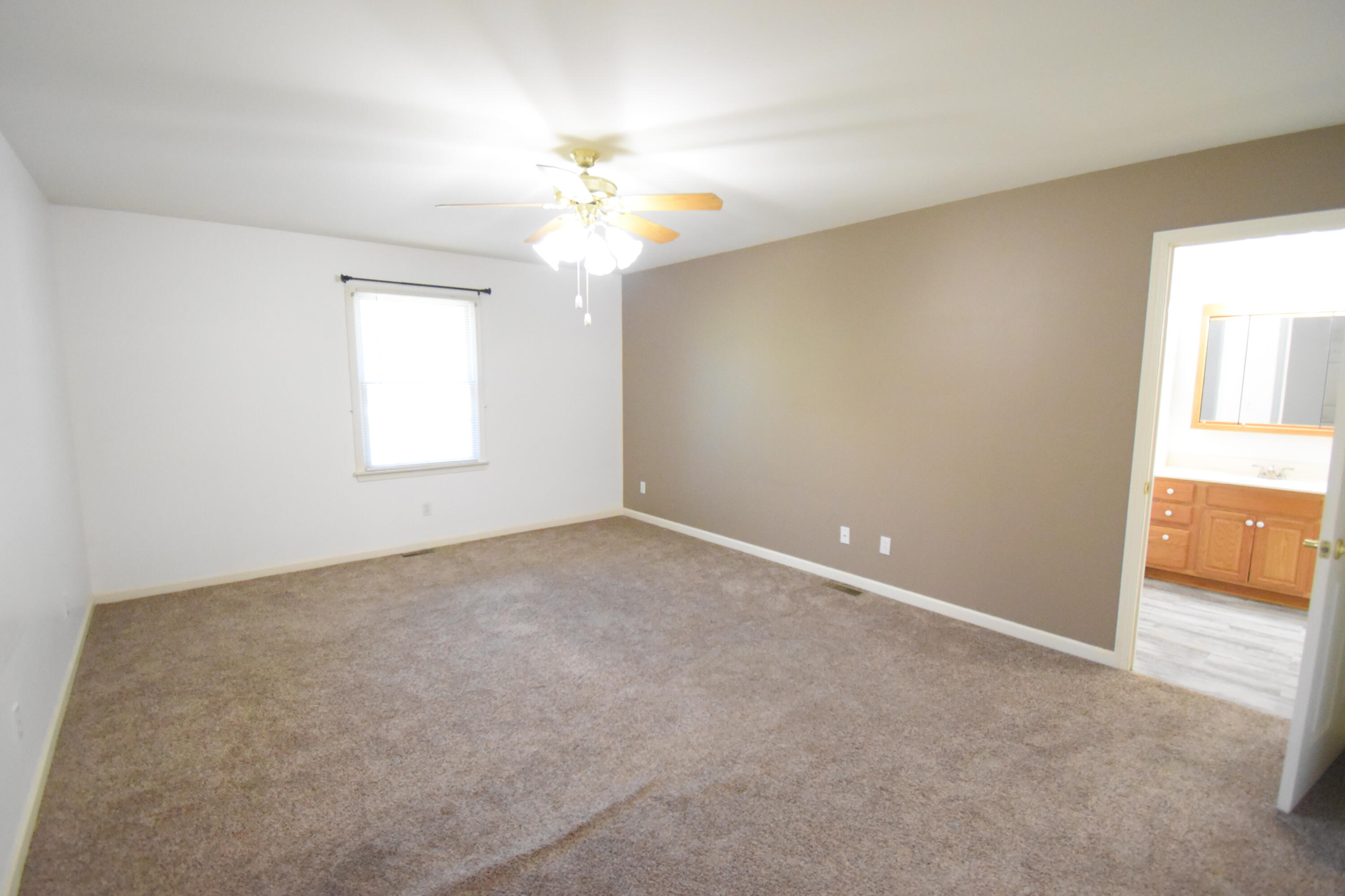 522 Pheasant Run Rensselaer, IN 47978 - Photo 33 of 55 an empty room with a chandelier fan and windows