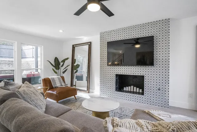 a living room with furniture a chandelier and kitchen view