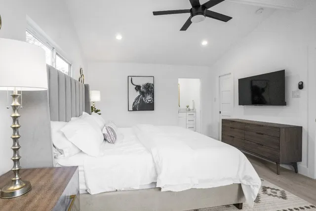 a bedroom with a bed wooden floor and a table