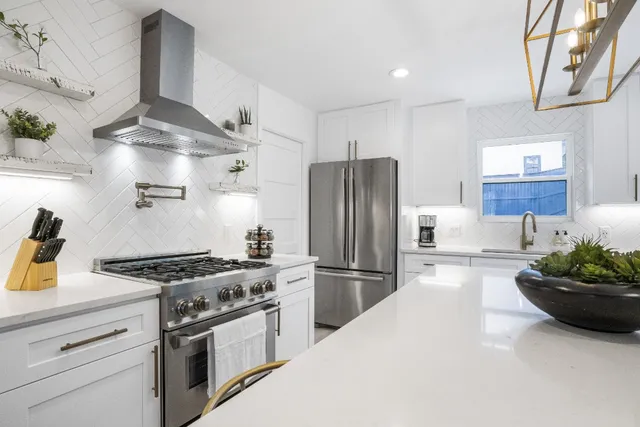 a kitchen with stainless steel appliances granite countertop a sink stove and refrigerator