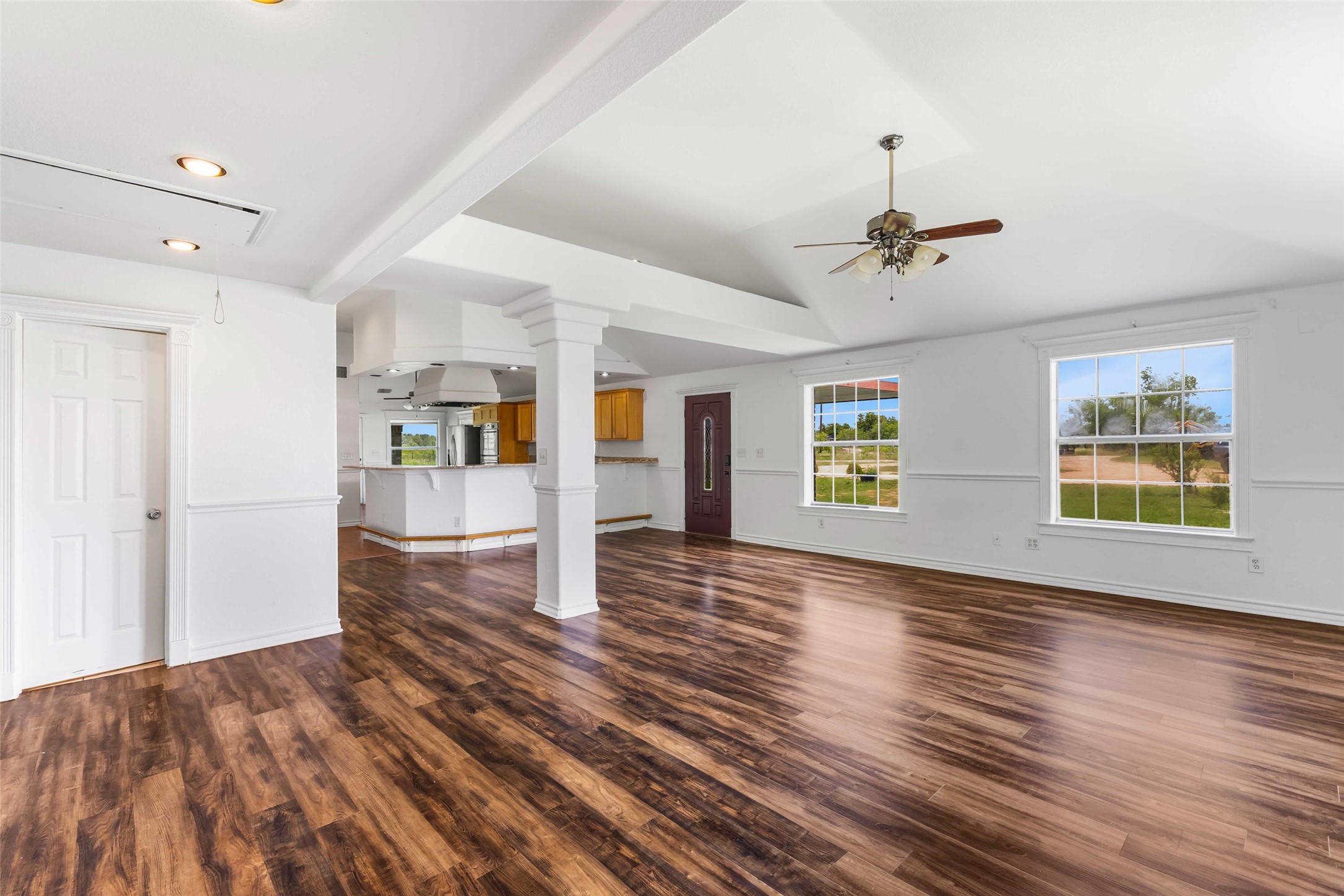 12212 Ballerstedt Road Elgin, TX 78621 - Photo 8 of 39 Unfurnished living room featuring dark wood-type flooring, a ceiling fan, and lofted ceiling