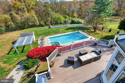 a view of a deck with couches table and chairs with wooden floor and fence
